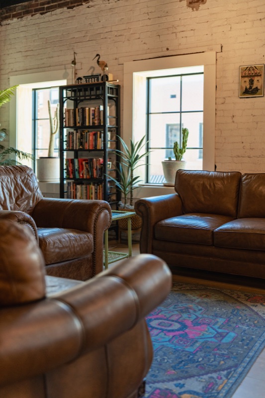 The lounge area inside Crane Coffee's Concord shop with leather couches and exposed brick walls