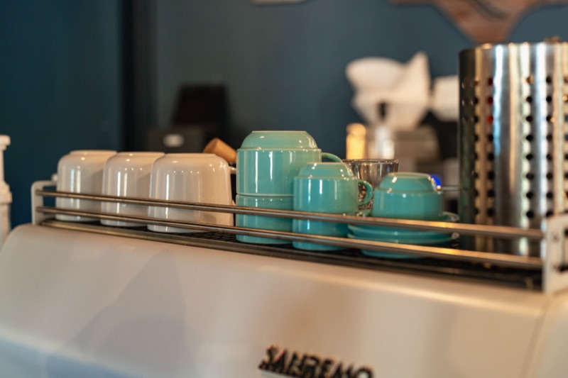 A row of blue glass syrup bottles on the Crane Coffee bar