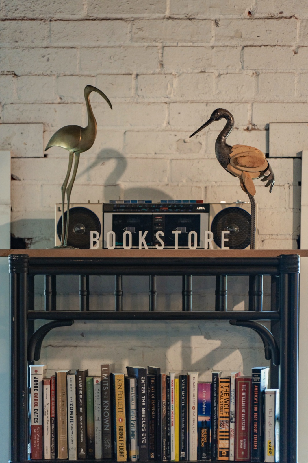 The Crane heron artwork and vintage bookshelf inside Crane Coffee's Concord shop at The District Exchange